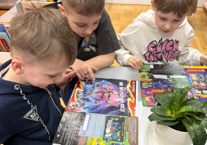 Chłopcy oglądają czasopisma.