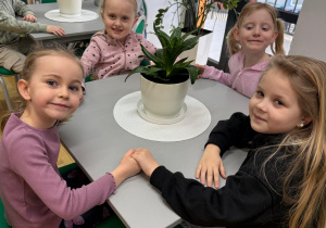 Dziewczynki siedzą w bibliotece.