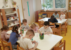 Dzieci kolorują przy stoliczkach.
