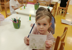 Dziewczynka pokazuje wykonane zadanie.