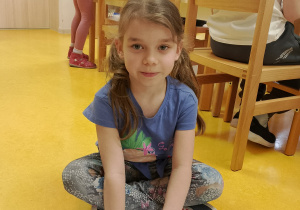 Dziewczynka uzupełnia książeczkę.