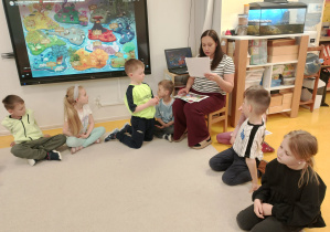 Dzieci siedząc w kole słuchają opowiadania o Tremku.