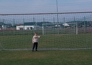 Chłopiec stoi na bramce.