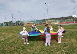 Dzieci bawią się z użyciem chusty animacyjnej.