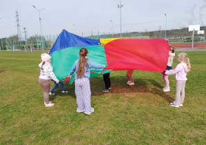 Dzieci bawią się z użyciem chusty animacyjnej.