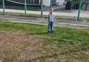 Chłopiec stoi na bramce.