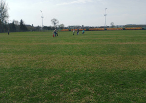 Dzieci biegają po boisku.