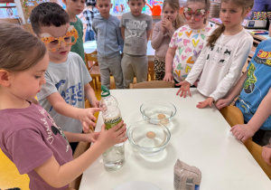 Dzieci nalewają ocet do słoika.