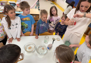 Pani pokazuje co będzie potrzebne do wykonania eksperymentu.