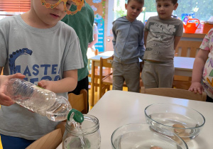 Chłopiec nalewa ocet do słoika.