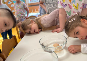 Dzieci porównują czy w zasolonej wodzie jajko pływa.
