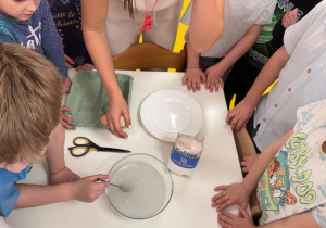 Chłopiec miesza wodę z solą.