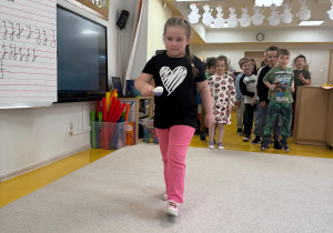 Dziewczynka idzie z jajkiem na łyżce.