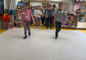 Dzieci idą z jajkami na łyżkach.