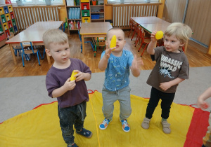 09. Chłopcy trzymają żółte owoce.