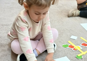 12. Dziewczynka układa rytmy z jabłuszek.