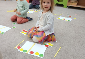 14.Dziewczynka układa rytmy z jabłuszek.