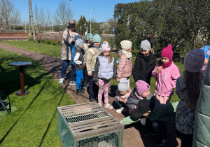 Dzieci stoją przed wejściem na gospodarstwo.