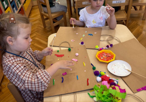 Dziewczynki pracują w skupieniu nad swoimi projektami
