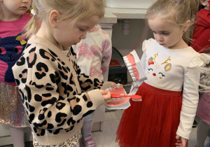 Dziewczynka czyści zęby na modelu szczęki.