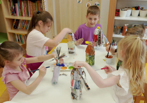 Dzieci pracują przy stoliczkach.