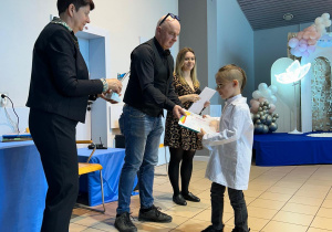 Chłopiec odbiera nagrodę od jury.