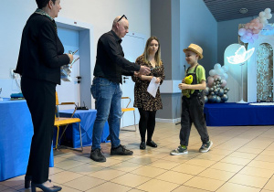 Chłopiec odbiera nagrodę od jury.