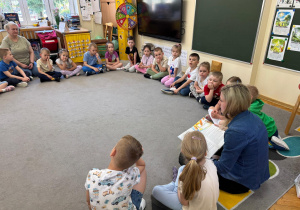 Dzieci z zainteresowaniem słuchają opowiadania.