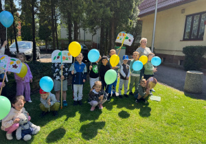 Dzieci z plakatami i balonami w ręku.