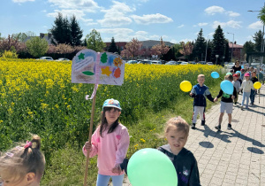 Dziewczynki z plakatem i balonami w ręku.