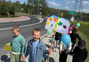 Chłopcy z banerem promującym czytelnictwo.