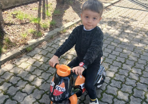 08. Chłopiec siedzi na motorku.