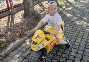 09. Chłopiec siedzi na motorku.