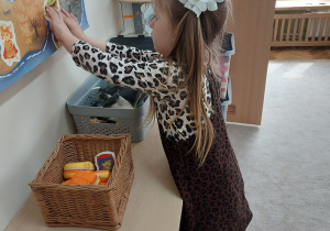 Dziewczynka zawiesza na planszy Pana Ble.