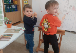 Chłopcy dorysowują kolejne elementy w obrazku.