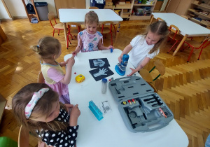 Dziewczynki oglądają przybory chemiczne.