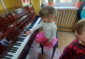 Dziewczynka gra na pianinie.