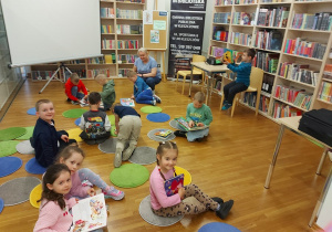 Dzieci siedzą na podłodze i oglądają książki