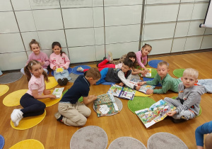 Dzieci oglądają książki w bibliotece
