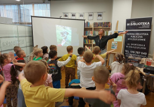 Dzieci z autorką książek wykonują ćwiczenia