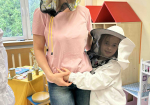 Dziewczynka w stroju pozuje z mamą.