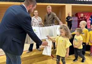 Dziewczynka odbiera nagtodę.