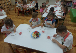 Dzieci kroją owoce.