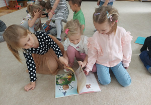 Dziewczynki oglądają książki przyniesione z biblioteki.