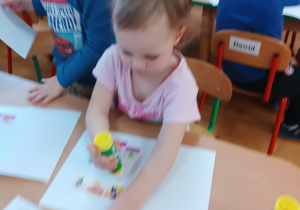 06 Dziewczynka przykleja Tremka do książeczki