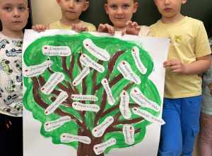 Chłopcy trzymają w ręku plakat wykonany przez całą grupę.