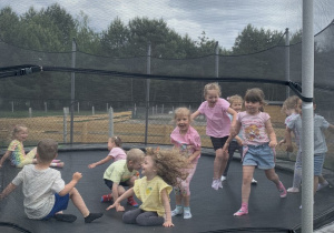 Dzieci skaczą na trampolinie.