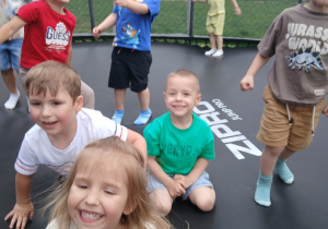 Dzieci bawią się na trampolinie.