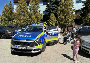 Dzieci oglądają wóz policyjny.