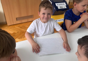 Uśmiechnięty chłopiec czeka na rozpoczęcie pracy.